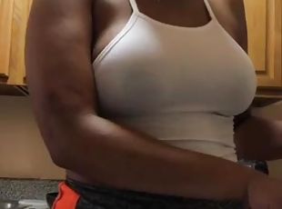Busty young black girl is making food in kitchen and shaking tits