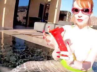 Red XXX fucks her pussy with a toy in the pool