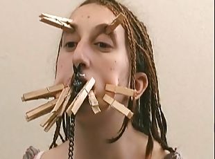 Both girl with clothes pins on her face